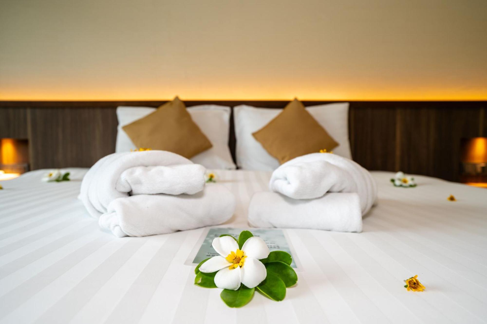 Le Resort And Villas Rawai Екстериор снимка A bed with towels and flowers